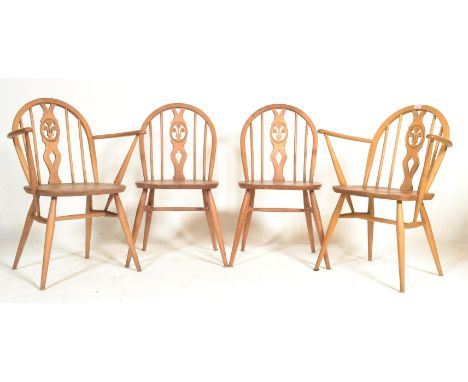 A set of 4 20th century Ercol beech and elm wood ' Fleur de Lys ' pattern dining chairs. Each raised on turned legs united by