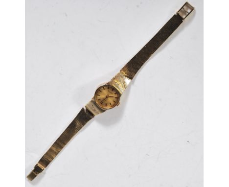 A vintage ladies 9ct gold Bulova Quartz cocktail watch having a round face with gilt dial with baton markings to the chapter 