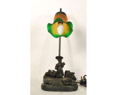 A 20th Century sculptural&nbsp; table lamp depicting a young girl holding a teddy collecting flowers, set on a naturalistic b