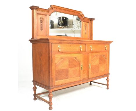 An early 20th Century 1920's light oak sideboard having a&nbsp;raised arched back with central mirror plate flanked by carved
