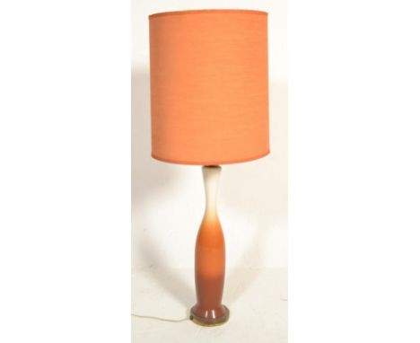 A vintage retro mid 20th Century desk / table top lamp having a flow orange ceramic base with an orange fabric upholstered cy