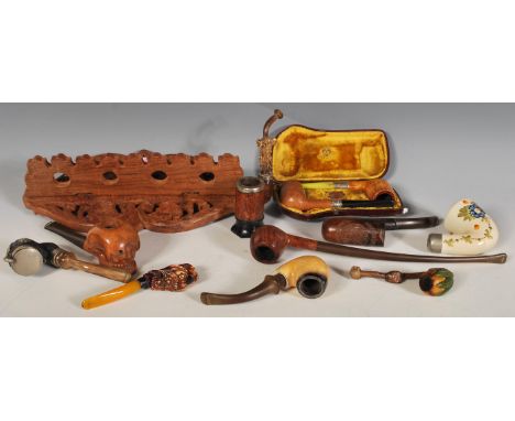 A selection of vintage 20th Century smoking pipes to include a meerschaum pipe carved holding pomegranates, briar pipes, a Pe