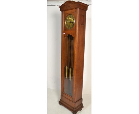 A 1920's oak and brass faced longcase / grandfather clock. The hood with bevelled glass front enclosing large brass round dia