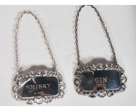Two silver hallmarked decanter labels to having rectangular panels with scrolled shell decoration borders, one engraved ' Gin