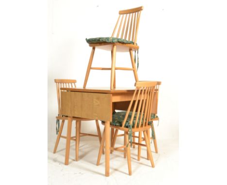 A retro mid 20th Century 1960's wood effect Formica topped drop leaf kitchen dining table raised on rounded legs. Together wi