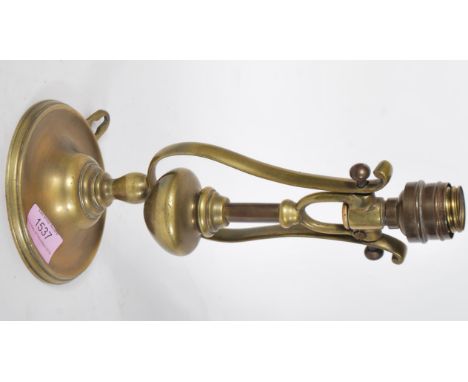 A 19th Century cast brass Pullman carriage gimbal lamp having a round wall mount with lyre shaped support suspending a lamp s