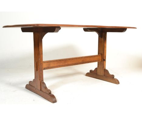 A 20th Century Ercol Old Colonial beech and elm dark wood refectory dining table raised on Windsor supports united by a singl