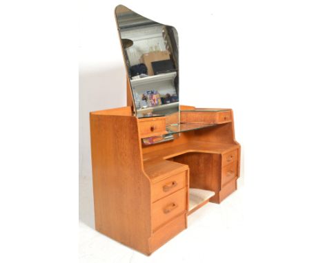 E. Gomme- G Plan- Brandon Range- A retro 1970's light oak dressing table having a large shaped tapering mirror. Two single sh