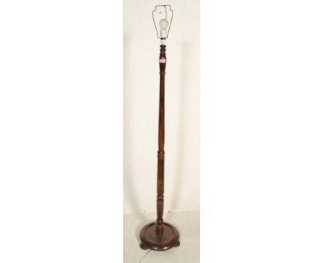 A 20th Century antique style turned wooden standard lamp having a knopped column terminating in a round base raised on tripod