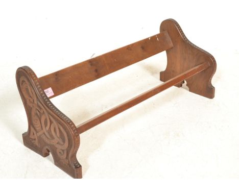 An early 20th Century fruit wood book trough of typical form having hand carved Celtic knotted dragon decoration to sides. Me