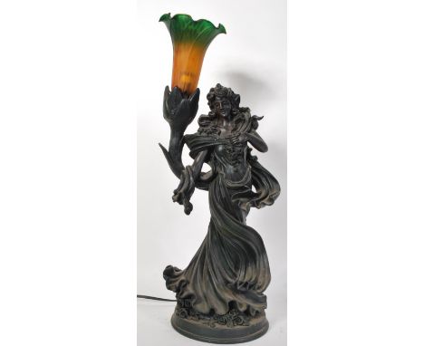 A 20th Century composite figural table lamp of a classical female holding aloft a cornucopia mottled coloured glass shade, ra