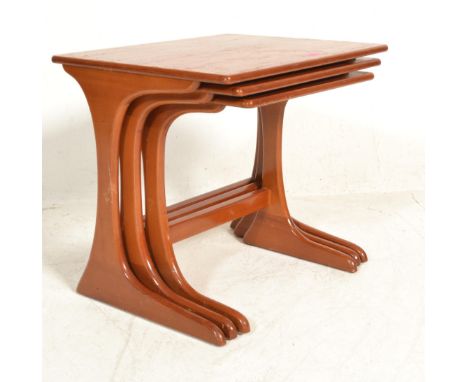 A nest of three vintage retro 20th Century Danish influenced teak wood nest of tables raised on bracket legs with rectangular