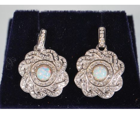 A pair of silver drop earrings of round knot form set with CZ's having central opal panels. Stamped 925. Gross weight 4.2g. M