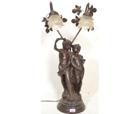 A 20th Century bronzed table lamp modelled in a classical style depicting young lovers in partial dress raised on a naturalis