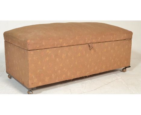 An early 20th Century floral fabric covered ottoman having a spring top to the hinged lid. The lid opens to reveal storage sp