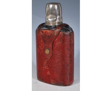 An early 20th Century glass hip flask having a red leatherette casing with white metal screw measure cap and glass stopper be