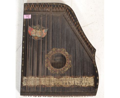 A early 20th Century ' The International ' guitar zither musical instrument having an ebonised back panel being printed with 