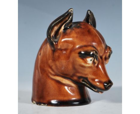 A 19th Century hunting interest ceramic stirrup cup in the form of a fox with stylised novelty features including bulging eye