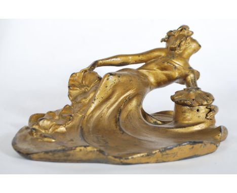 A late 19th Century / early 20th Century French Art Nouveau gilded cast metal inkwell in the form of a recumbent female figur