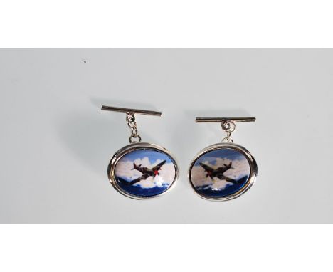 A pair of silver cufflinks of oval form having central enamel panels depicting spitfires amongst the clouds. Stamped 925 to v