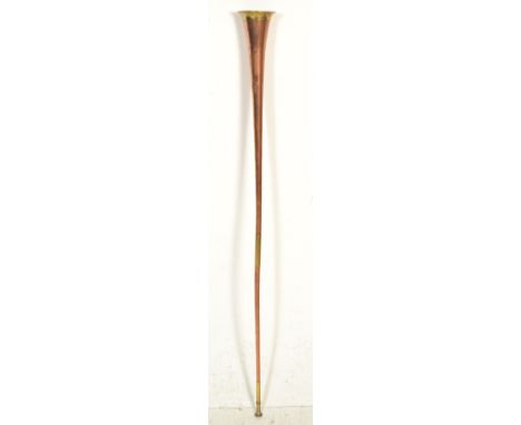 A late 19th / early 20th Century copper hunting horn of long form having contrasting brass fittings.&nbsp;