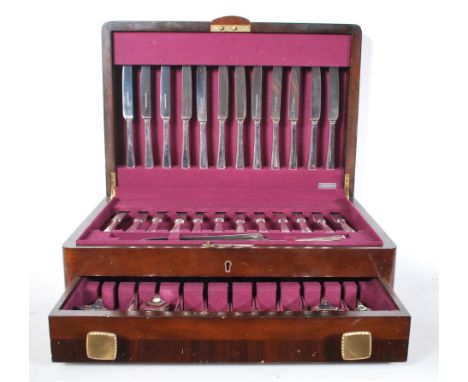 A vintage 20th Century cased canteen of cutlery. The hinged lid with drawer below opening to reveal an extensive service by W