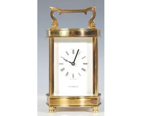 A vintage brass Carriage Clock of five-glass form, English made, white enamel face having a Roman numeral chapter ring stampe