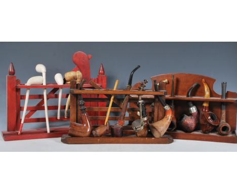 A collection of vintage and antique pipes over three pipe racks to include carved examples, briar, clay, calabash, ceramic et