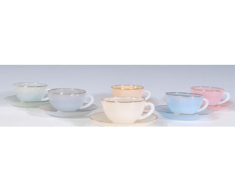 A vintage 1930's Art Deco French pearlware ceramic tea set to include six cups and saucers in pastel colours with gilt rims.&