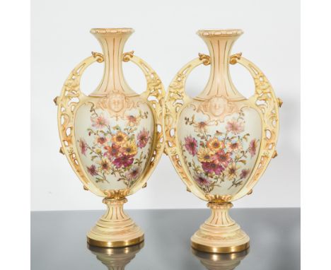 PAIR OF AUSTRIAN DOUBLE HANDLED BALUSTER VASES
with a moulded mask to each side and floral decorated panels below on an ivory