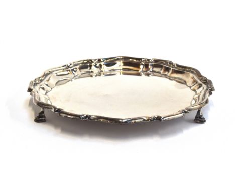 A small silver salver by Mappin &amp; Webb, Sheffield 1910, shaped edge, on three hoof feet, 21cm diameter, 11.6oz 