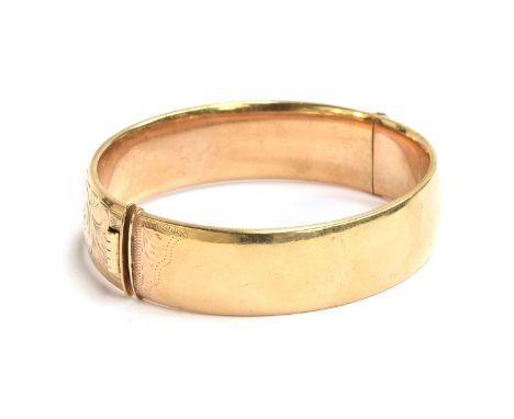 A 9ct bangle, engraved leafage scrolls to the front, marked R&amp;W, Birmingham 1989, 37g 