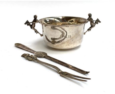 A silver tastevin, the twin handles in the form of jockeys astride hobby horses, Mappin &amp; Webb, Sheffield 1963, 10.5cm di