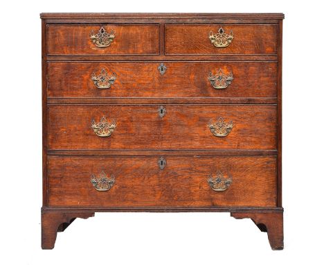 A George III oak chest of drawers, the top with reeded edge over two short and three graduating cockbeaded drawers, on bracke
