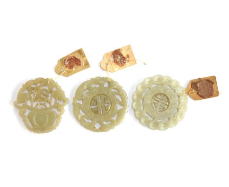 Three Chinese carved and pierced jade medallions, two with reticulated shou medallion to centre, the third in the form of a f