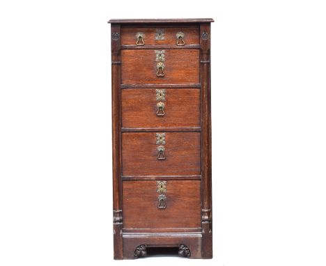 A tall oak chest of drawers by Gillows of Lancaster, comprising narrow drawer over a further four deep drawers, flanked by fa