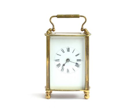 A French gilt metal carriage clock with bevelled glass, enamel dial with Roman numerals, 14.5cm high to top of handle 