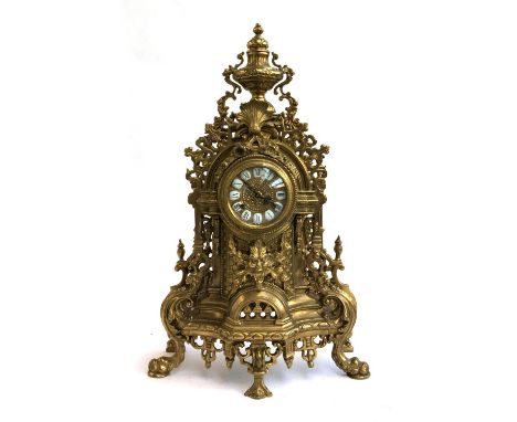 A 20th century mantel clock in a Baroque brass ormolu style case, the dial having inlaid enamel numerals and pierced hands, u