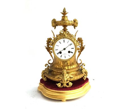 A French brass mantel clock, having ram's head and scrolling acanthus decoration, the dial with roman numerals, Simmons Paris