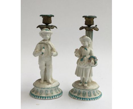 A pair of white and green glazed figural ceramic candlesticks 