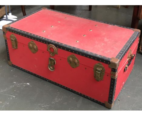 A red canvas covered travel trunk 