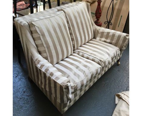 A Howard style contemporary two seater sofa, upholstered in a striped fabric, on tapered legs with brass casters, approx. 130