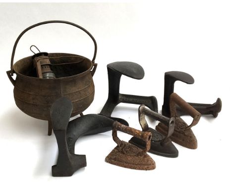 Three 19th century flat irons; three cast irons shoe slobs and a three legged cauldron and oil lamp; together with two large 