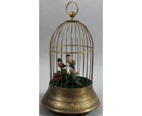 A 20thC metal cased three bird automaton, set with sparse floral arrangement with a pierced wirework dome top and articulated