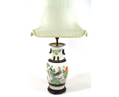 An early 20thC Chinese pottery lamp vase, with an upper raised banding decorated with birds and flowers predominately in gree