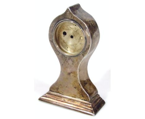 An early 20thC silver watch case clock, of shaped outline on triple supports, marks rubbed, 14cm high, 5oz all in. (weighted,