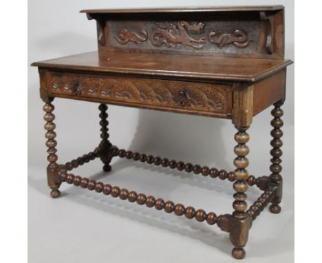 A 19thC oak serving table, the canopy top raised above a heavily carved back set with stylised serpents and scrolls above a h