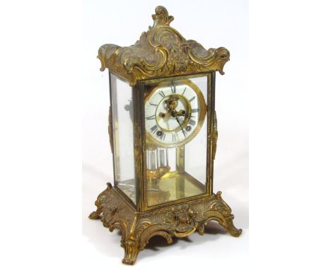 A late 19thC rococo style gilt metal mantel clock, 11cm dia Roman numeric dial with visible workings in a four part glazed ca