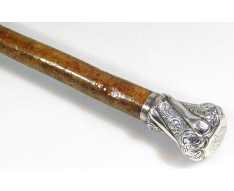 A walking stick, with repoussé decorated silver knop and metal tip end, 89cm high.