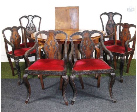 A late 19thC Chinese dining table, of oval outline with carved centre, on heavy cabriole supports terminating in stylised cla